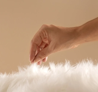 Hand touching soft rabbit fur, representing premium wool and fur products offered through rabbit farming at Abungu